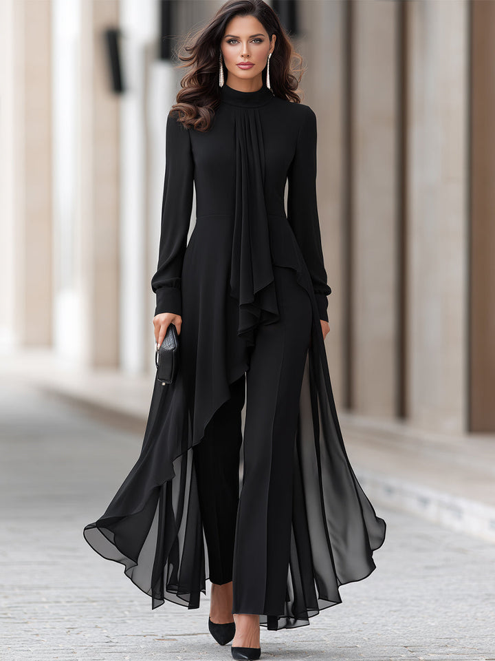 Helfigursbillede af model i sort sæt med lang, asymmetrisk chiffon-tunika, vide bukser, sorte pumps og lille clutch. 2