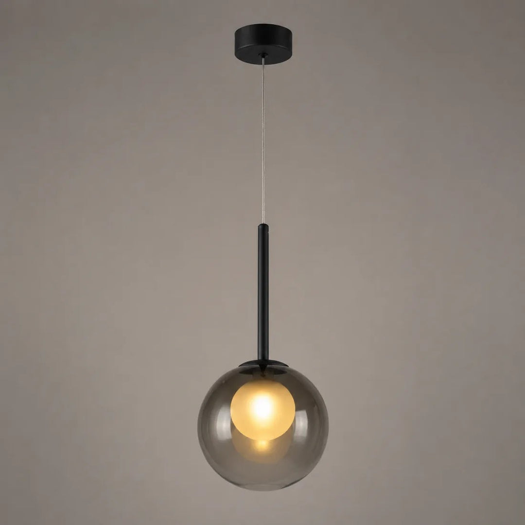 Tændt røggrå glaskuglelampe med sort stang, fotograferet foran en grå væg 10