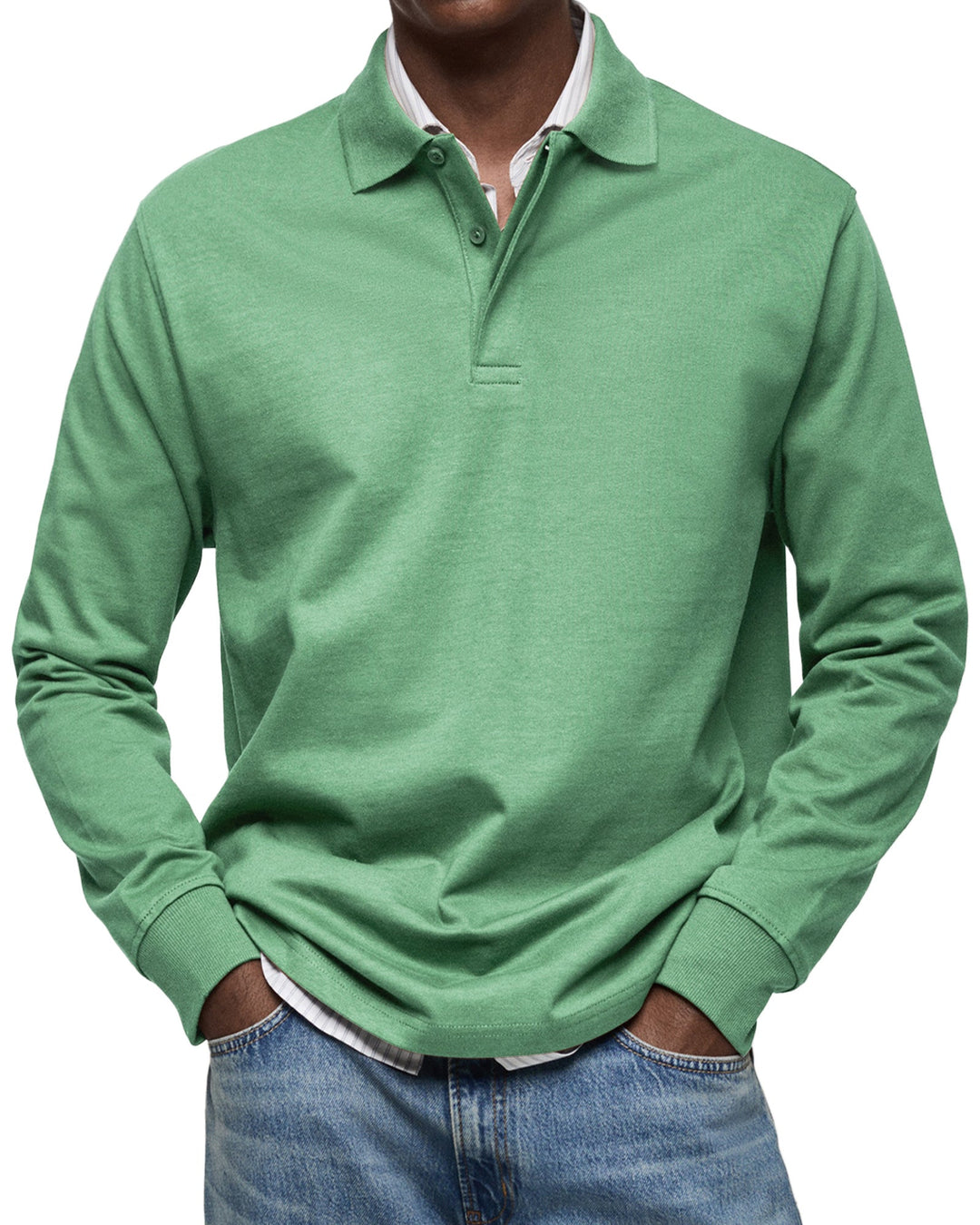 Langærmet poloshirt i grøn, båret af en model med stribet skjorte under og jeans, set forfra. 7
