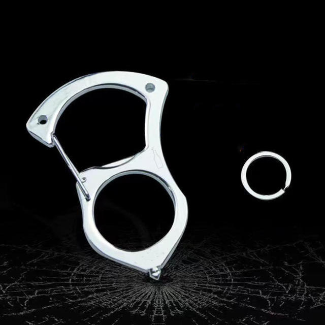 Nøgleholder i blankt stål uden greb på sort baggrund med sprukket glasmønster, ved siden af en separat lille splitring. 4