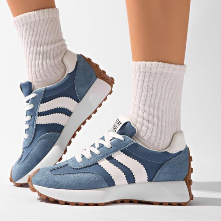 Blå sneakers med hvide striber og gummisål med knopper båret med hvide sokker, set fra siden 8
