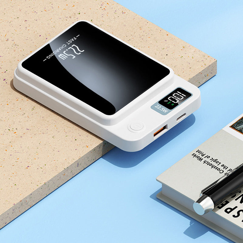 Hvid powerbank liggende fladt på en overflade, med USB-udgang, USB-C-port, tændknap og digitalt display synlige. 6