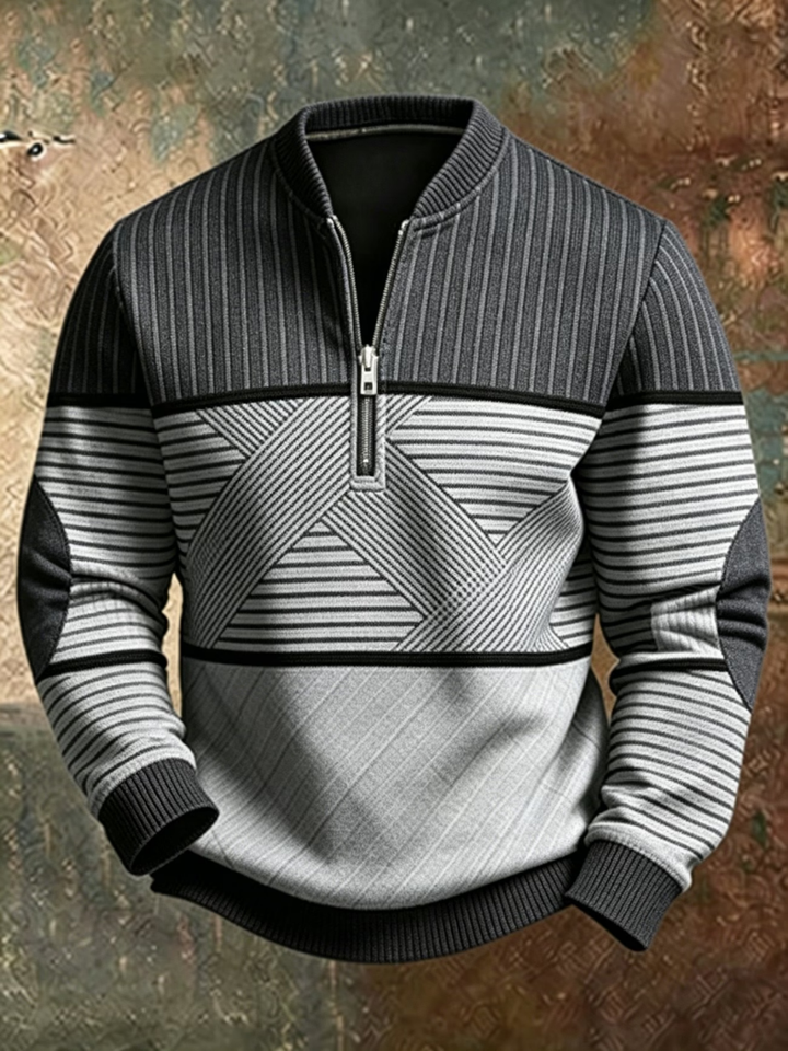 Samme sweater i grå og sort med lodrette, vandrette og diagonale striber, halv lynlås og ribkant, set forfra. 2