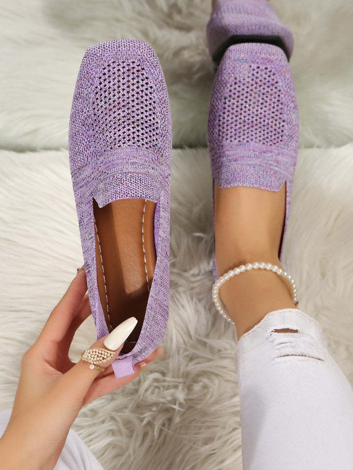 Lilla slip-on sko set ovenfra, hvor en hånd holder den ene sko og viser den brune indersål. 11