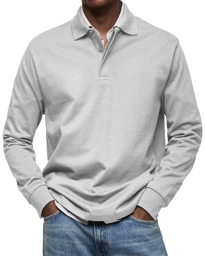 Langærmet poloshirt i lysegrå, båret af en model med stribet skjorte under og jeans, set forfra. 5