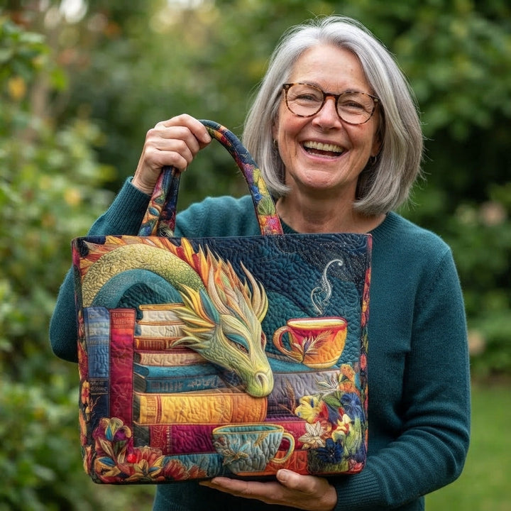 Smilende kvinde med gråt hår og briller holder den vatterede totebag med drage, bøger og tekopper foran sig i en have. 2
