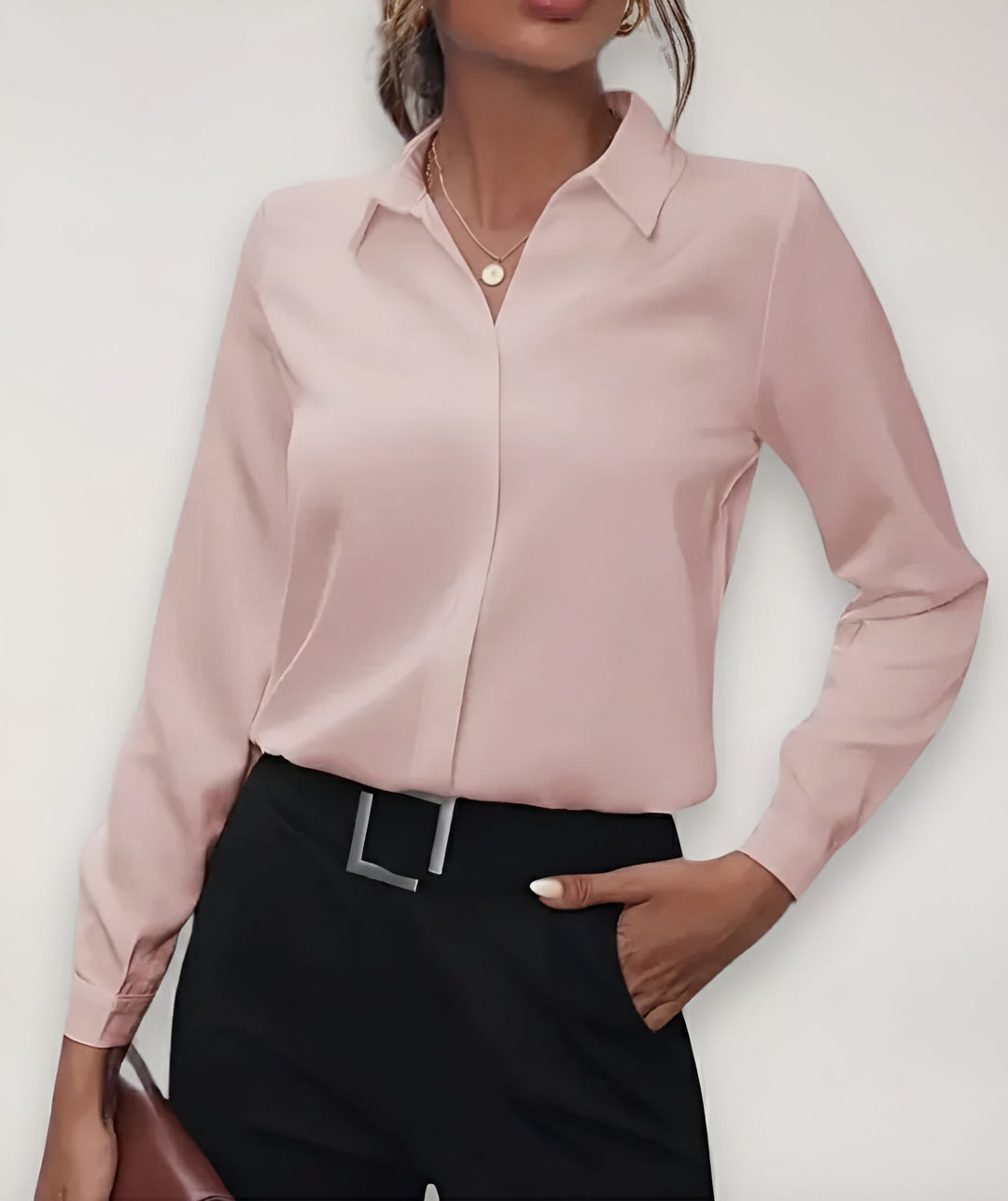 Model set forfra i lyserød bluse med klassisk krave, sorte bukser og hånd i lommen 2