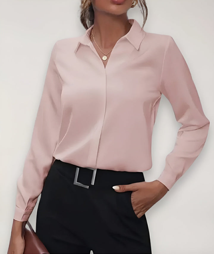 Model set forfra i lyserød bluse med klassisk krave, sorte bukser og hånd i lommen 2