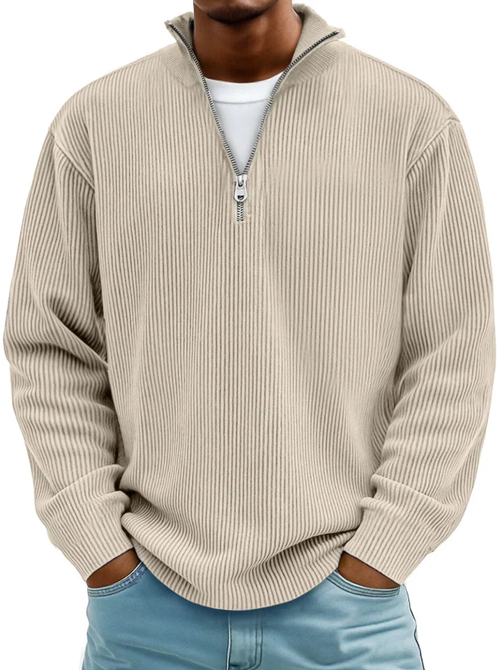 Model i beige ribstrikket sweater med lynlås ved halsen, hænderne i lommerne på jeans 4