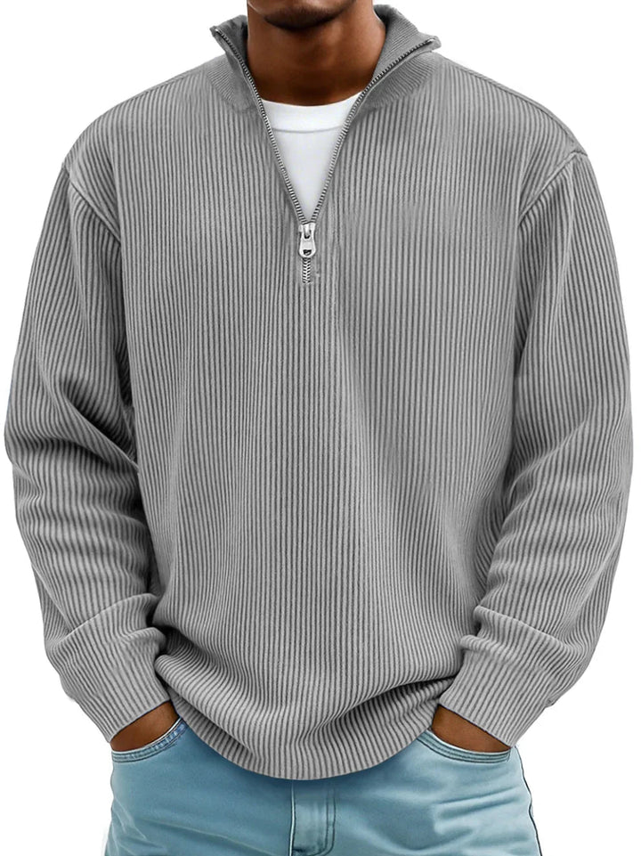 Model i grå ribstrikket sweater med halv lynlås og stående krave, set forfra 2