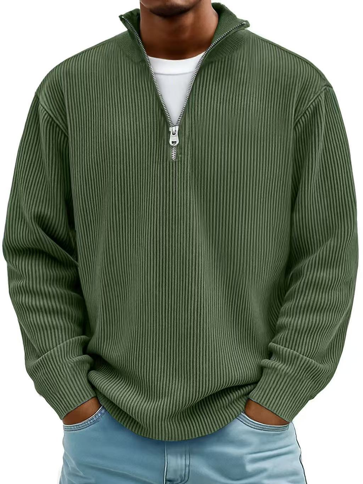 Model i grøn ribstrikket sweater med delvist åbnet lynlås og krave, hvid t-shirt under 8