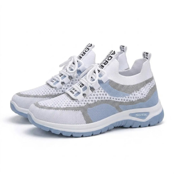 Et par hvide sneakers med blå sål og grå striber set på skrå forfra på hvid baggrund. 7