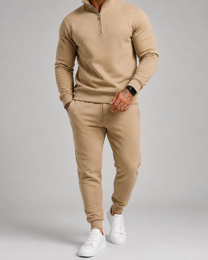Model i beige sæt med halv lynlås, hånden i lommen og hvide sneakers 5