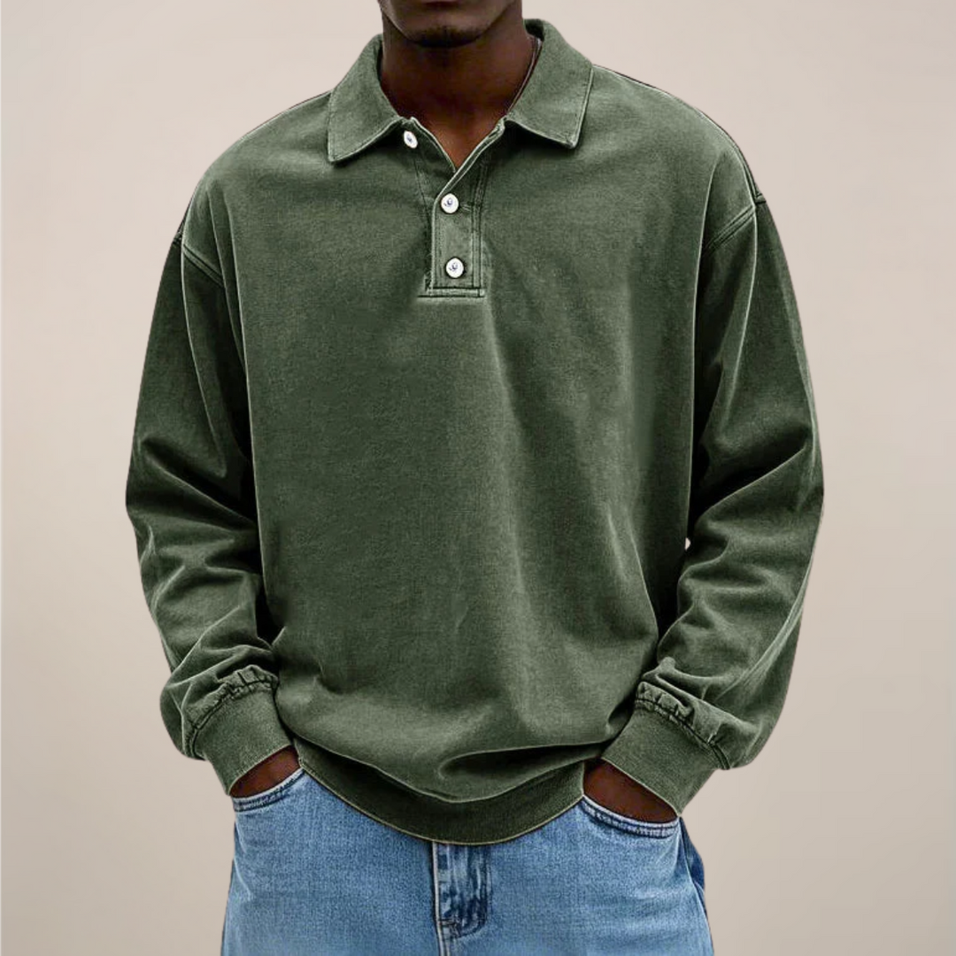 Model set forfra i grøn langærmet polotrøje med tre knapper og ribkant, kombineret med lyse jeans. 2