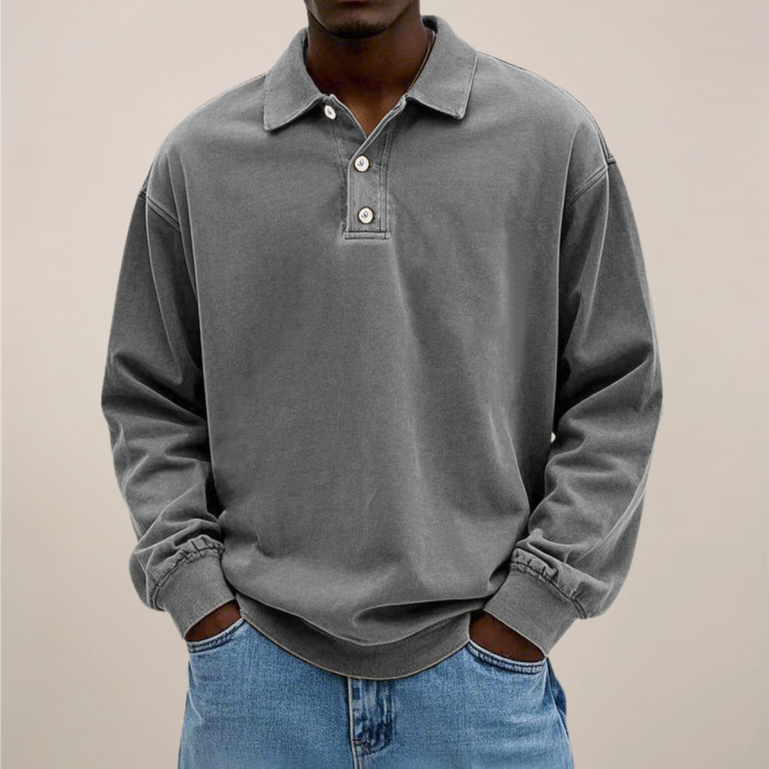 Model set forfra i grå langærmet polotrøje med krave og tre knapper, kombineret med lyse jeans. 7