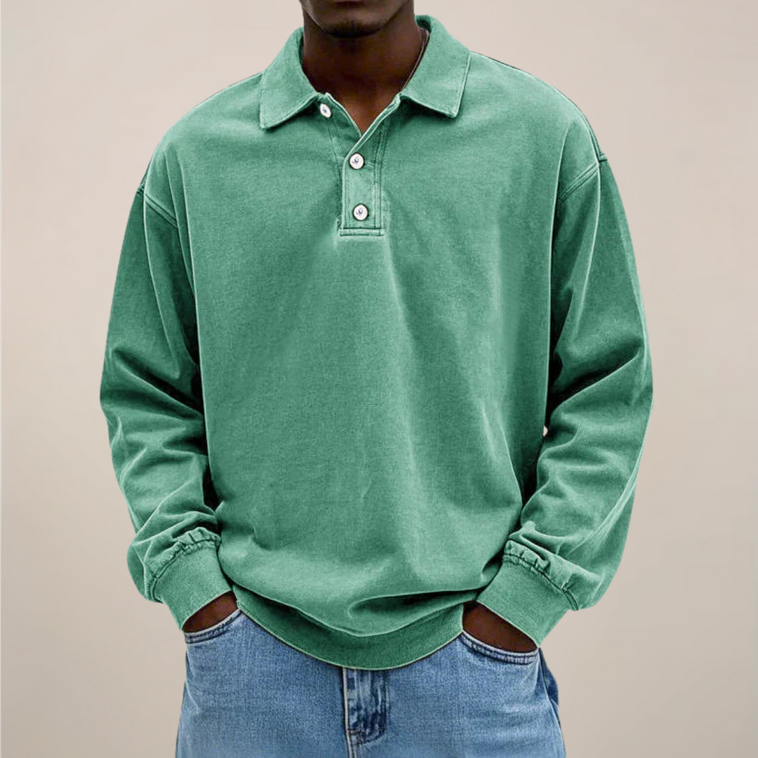 Model set forfra i mintgrøn langærmet polotrøje med knapper og løs pasform, hænderne i lommerne på jeans. 9