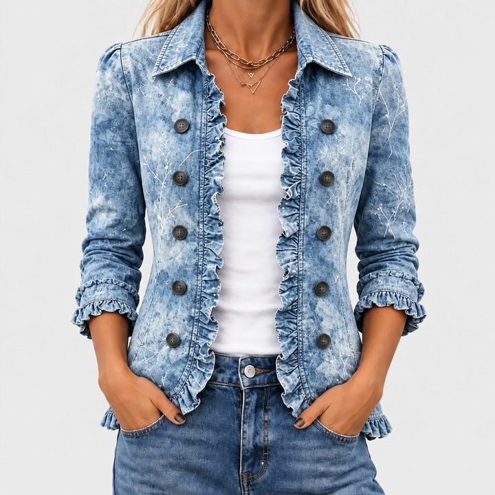 Nærbillede forfra af blå denimjakke med flæsekant og knapper, båret åben over hvid top 1