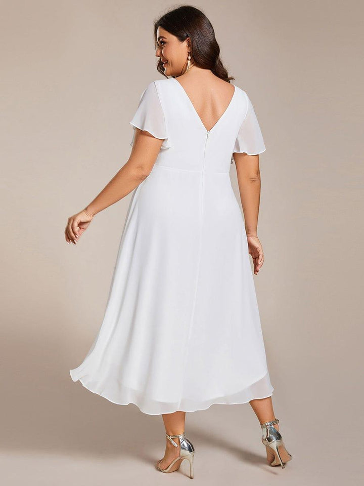 Bagsiden af den hvide kjole på plus size-model med V-udskæring i ryggen og lynlås. 74