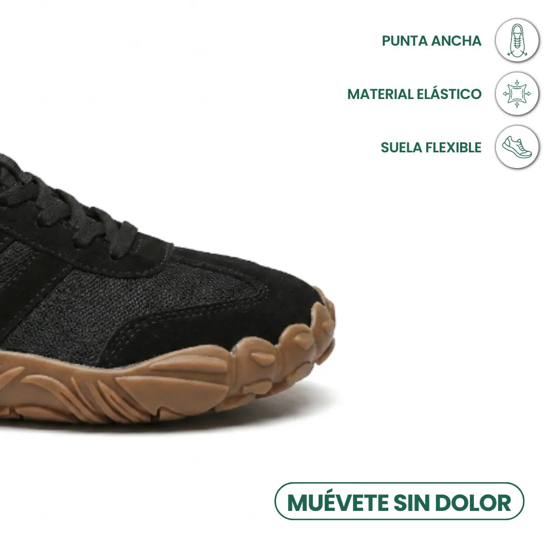 Nærbillede af den brede tåboks på den sorte sko med brun fleksibel sål og ikoner for bred tå og elastisk materiale. 23