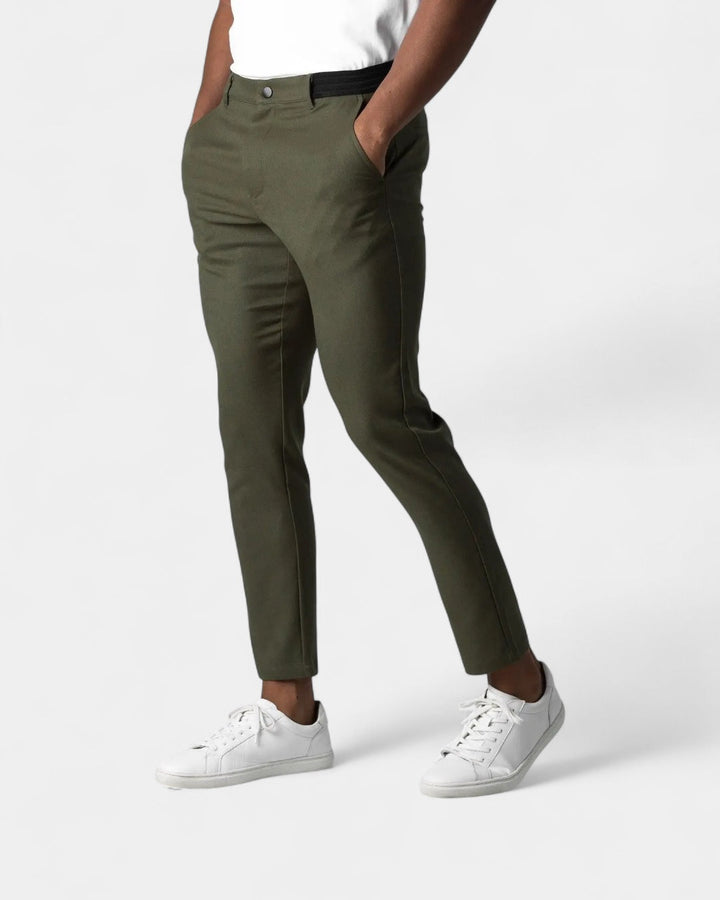Model i olivengrønne smalle bukser med elastiske taljesider, hvid t-shirt og hvide sneakers 4
