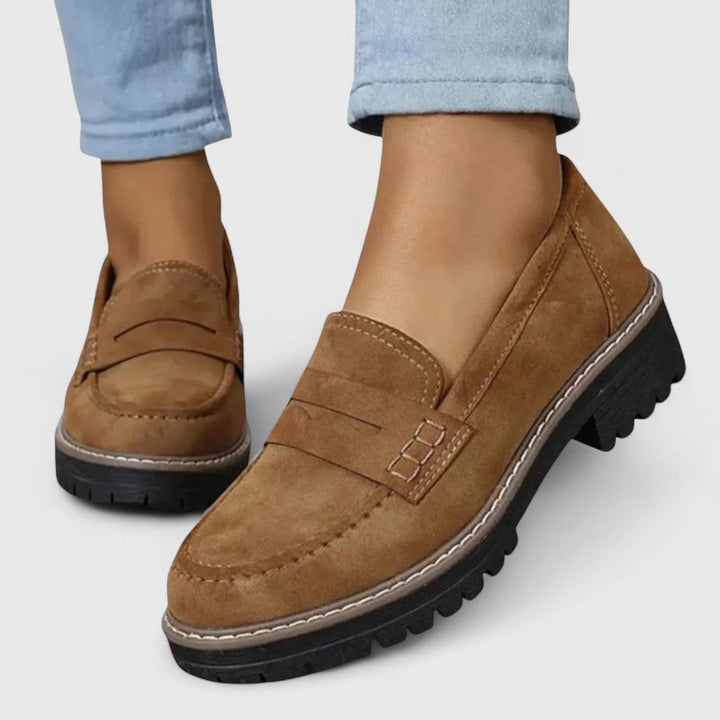 Brune loafers med hvide kontrastsyninger og kraftig sål båret med lyse jeans, tæt på 5