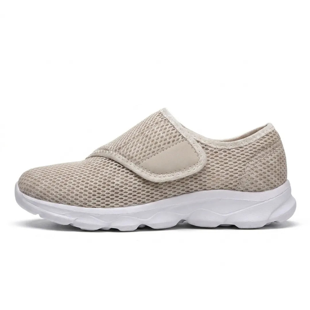 Beige mesh-sko set fra siden med velcrostrop over vristen og tyk hvid sål. 28