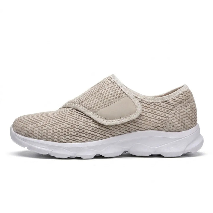 Beige mesh-sko set fra siden med velcrostrop over vristen og tyk hvid sål. 28