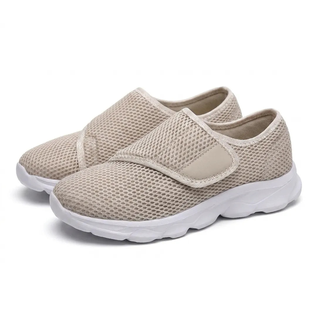 Et par beige mesh-sko med velcrostrop og hvid sål, set på skrå forfra på hvid baggrund. 34