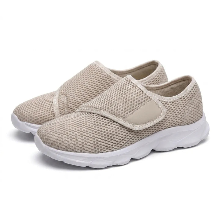 Et par beige mesh-sko med velcrostrop og hvid sål, set på skrå forfra på hvid baggrund. 34