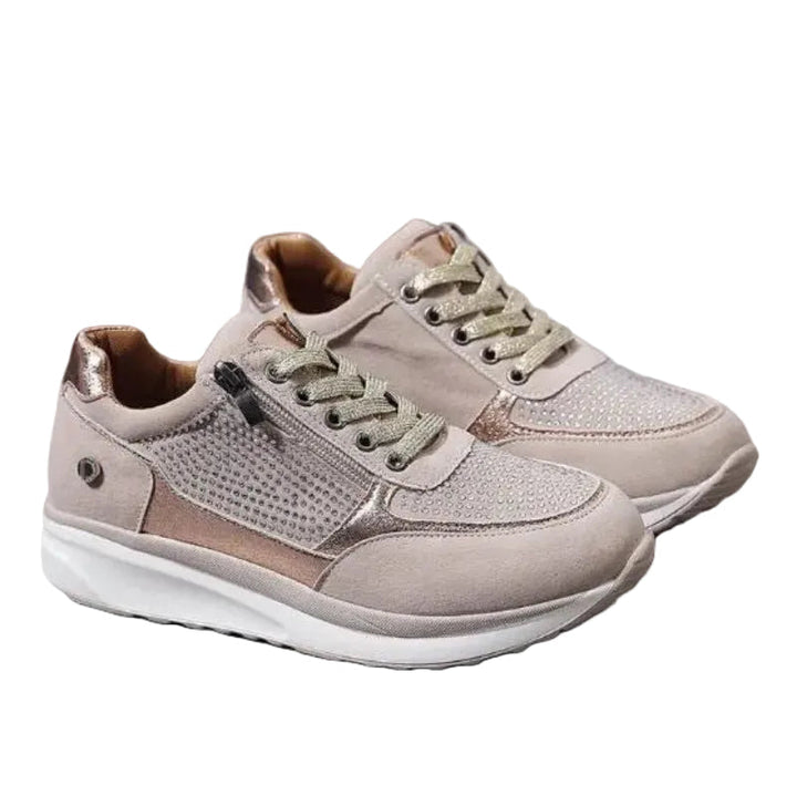 Par beige sneakers med glitrende snørebånd, lynlås i siden og hvid sål på hvid baggrund 1