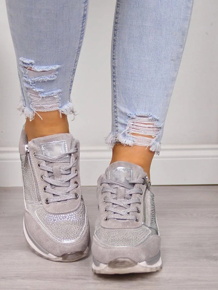 Grå sneakers set forfra på model, med snørebånd, glitterstene og lynlås i siden 6
