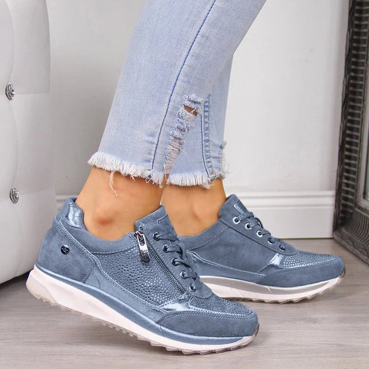 Blå sneakers med sidelynlås og snørebånd set fra siden på model i hullede jeans 3