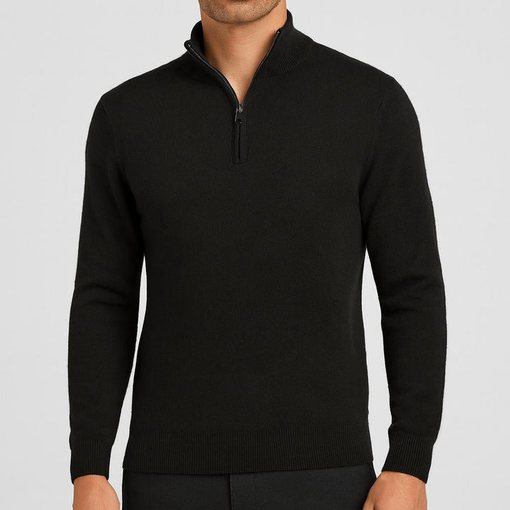 Model i sort strikbluse med lynlås i halsen og ribkanter, kombineret med sorte bukser, set forfra. 3
