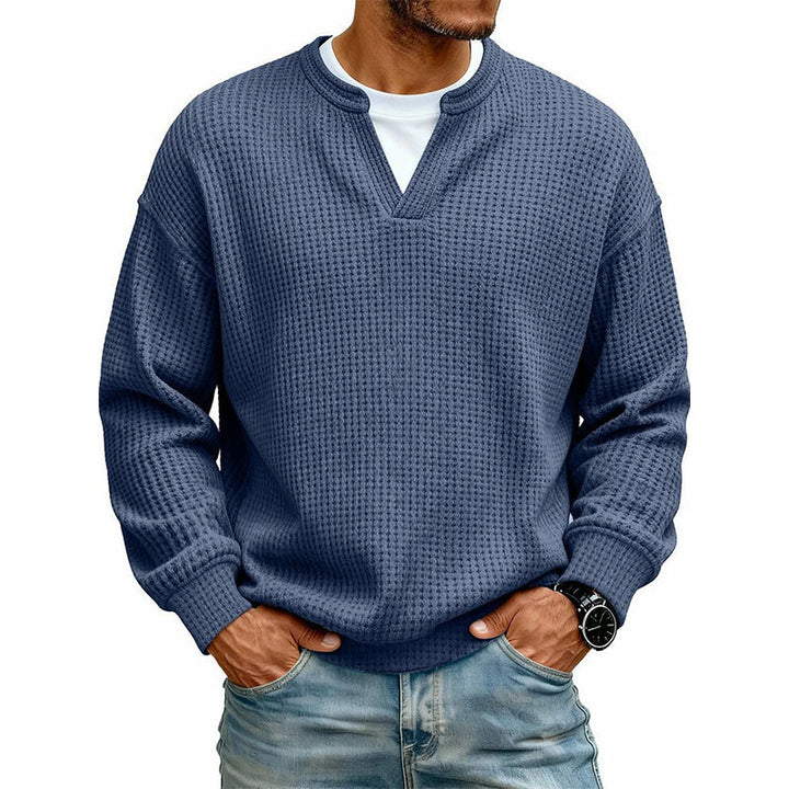 Model i mørkeblå vaffelstrikket trøje med V-udskæring, hvid t-shirt under og jeans 5