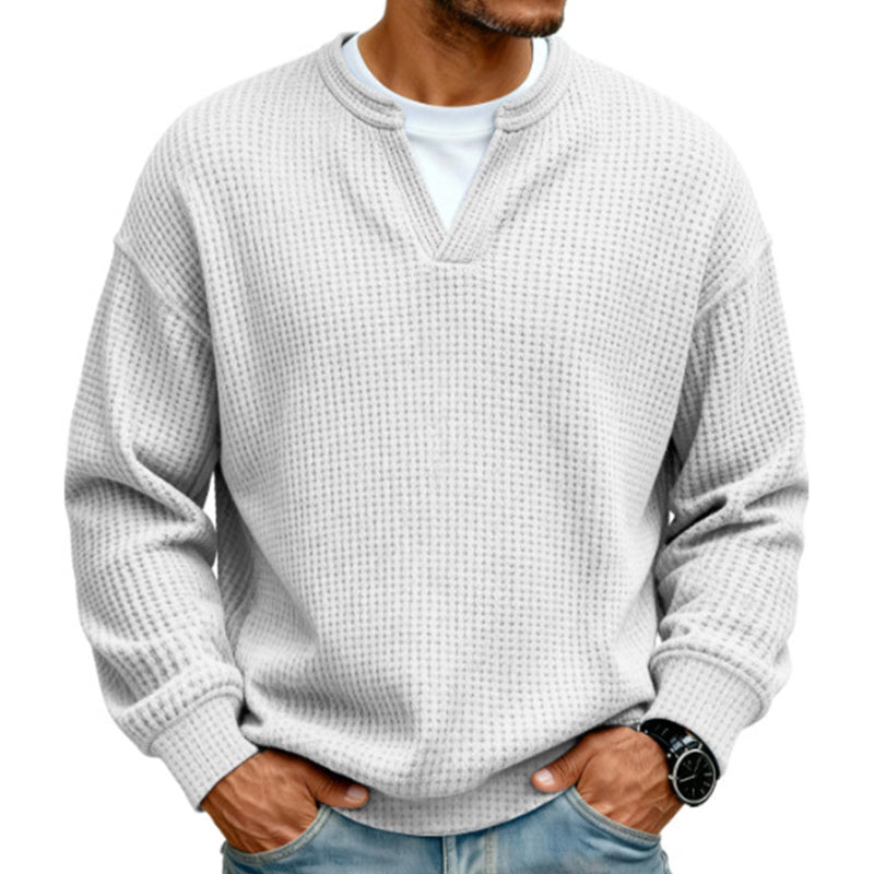 Lysegrå næsten hvid vaffelstrikket trøje med lagdelt krave, båret over hvid T-shirt af model med hænderne i lommerne. 8