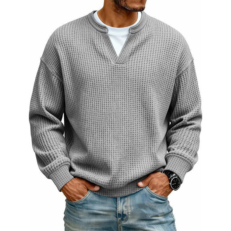 Grå vaffelstrikket trøje med lagdelt krave, båret over hvid T-shirt og jeans, set forfra på model. 11