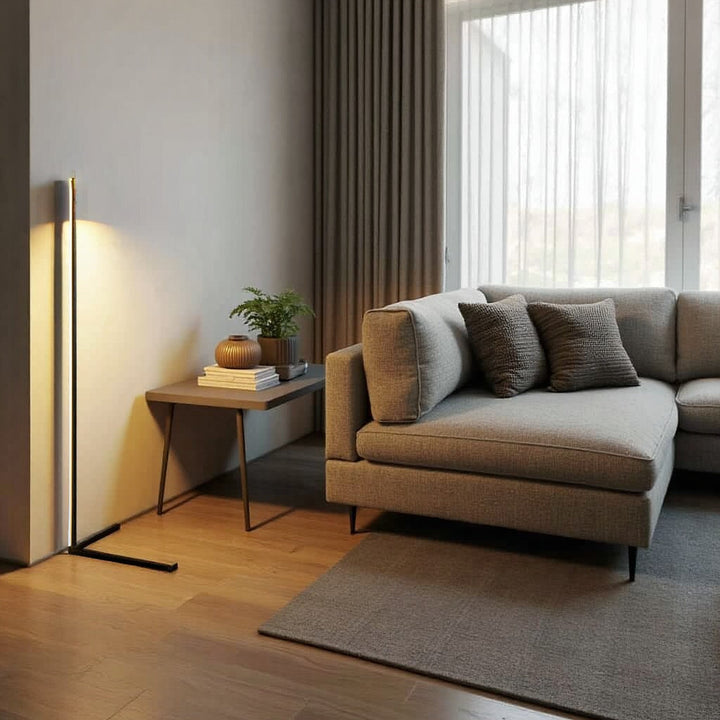 Tændt gulvlampe i lys stue med grå sofa, sidebord med plante og lange gardiner 6