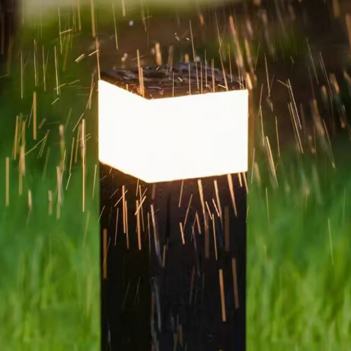 Detalje af den lysende top på en sort pullert i kraftig regn, der viser vandtæt udendørs brug. 9