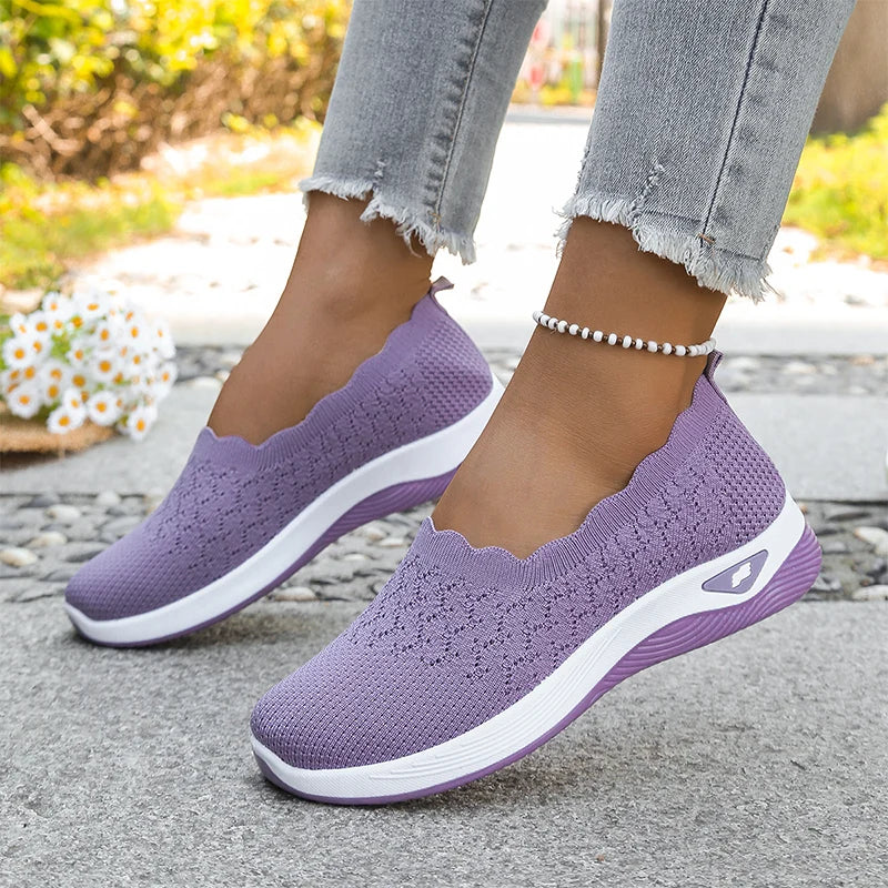 Lilla strikkede slip-on-sko med hvid mellemsål og lilla yderså, båret med jeans udendørs 19