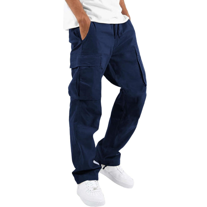 Model i marineblå cargobukser med store sidelommer og snøre i taljen, hvid T-shirt og hvide sneakers, set fra siden. 6