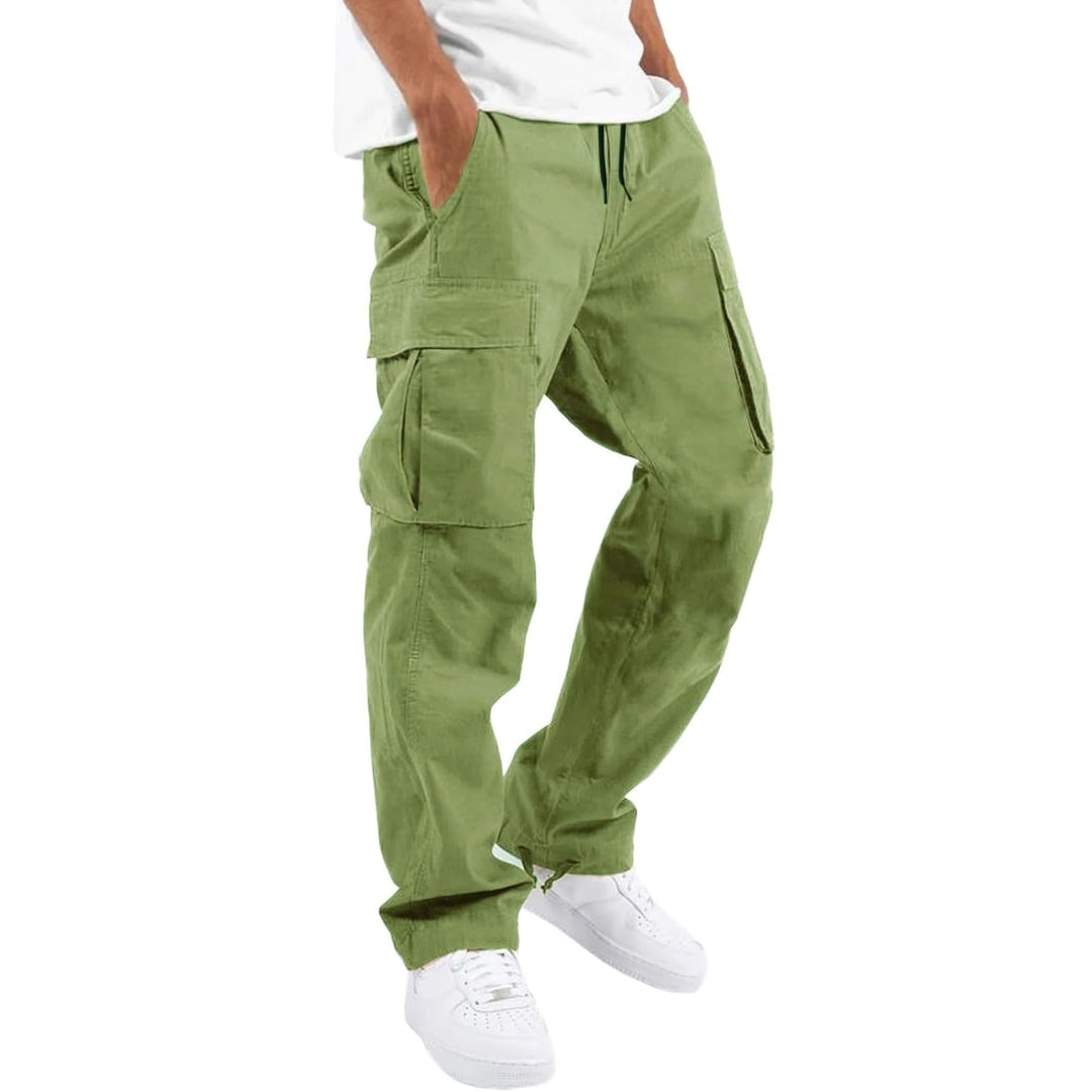 Model i lysegrønne cargobukser med store sidelommer og snøre i taljen, hvid T-shirt og hvide sneakers, set fra siden. 9