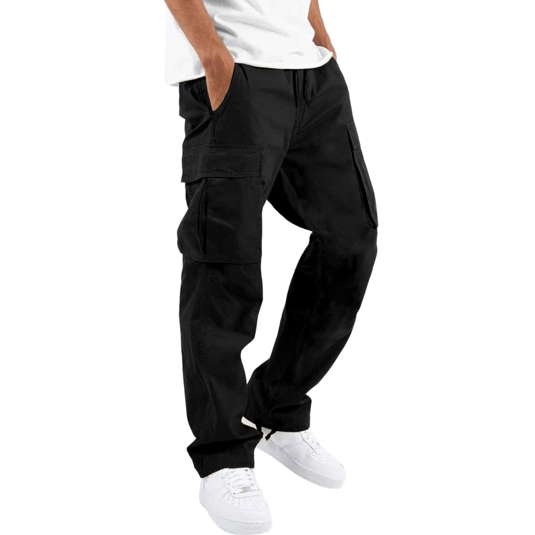 Model i sorte cargobukser med store sidelommer og snøre i taljen, hvid T-shirt og hvide sneakers, set fra siden. 4