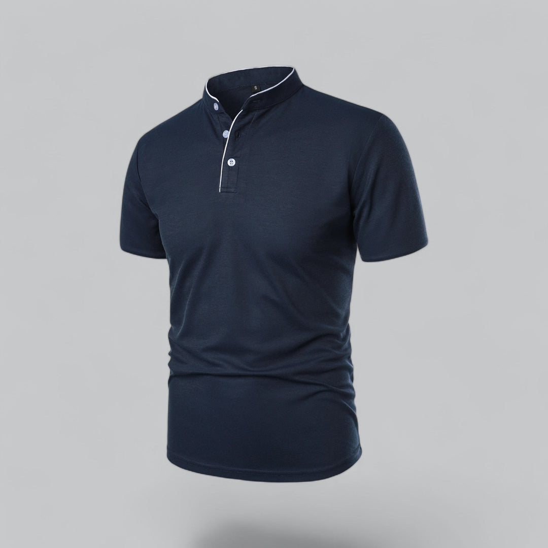 Marineblå poloshirt set skråt forfra med lyse knapper og hvidt kantbånd ved halsen 19