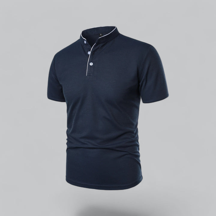 Marineblå poloshirt set skråt forfra med lyse knapper og hvidt kantbånd ved halsen 19