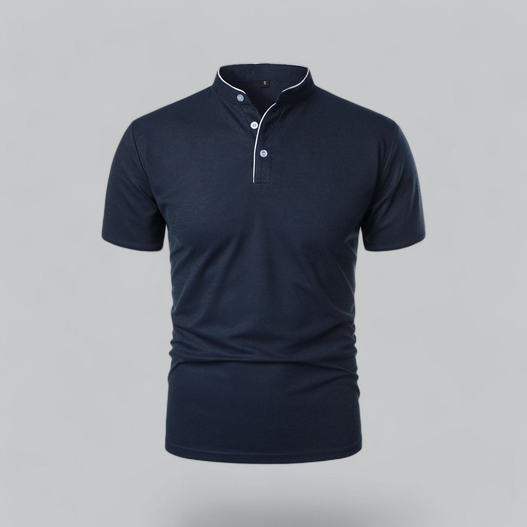 Marineblå poloshirt set forfra med ståkrave, lyse knapper og hvidt kantbånd langs knaplisten 5