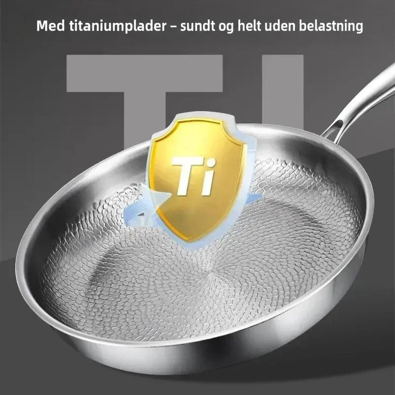 Pande med hamret bund og et gyldent skjoldsymbol over midten, der fremhæver titaniumlaget. 6