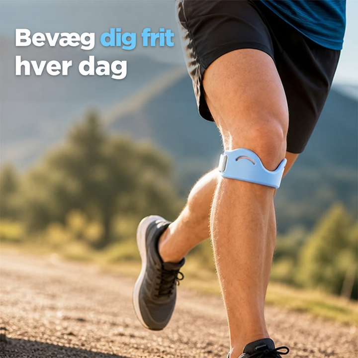 Løber på grusvej i bjergene med lyseblå knæstøttestrop under knæskallen, set fra siden med bevægelse i benet. 1