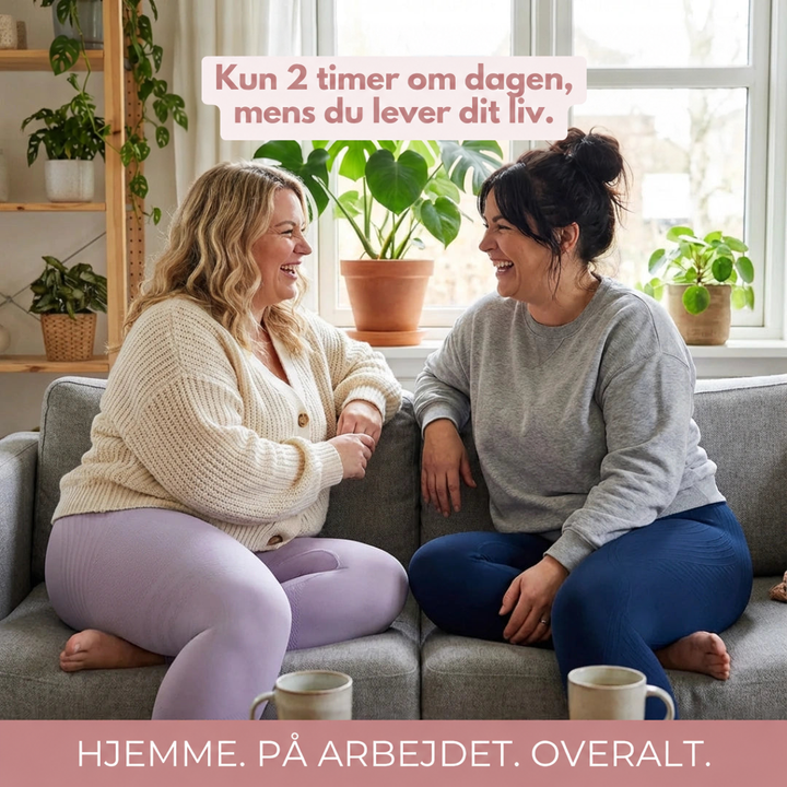 To smilende kvinder sidder på en grå sofa i lilla og marineblå leggings med kaffekopper foran sig. 16