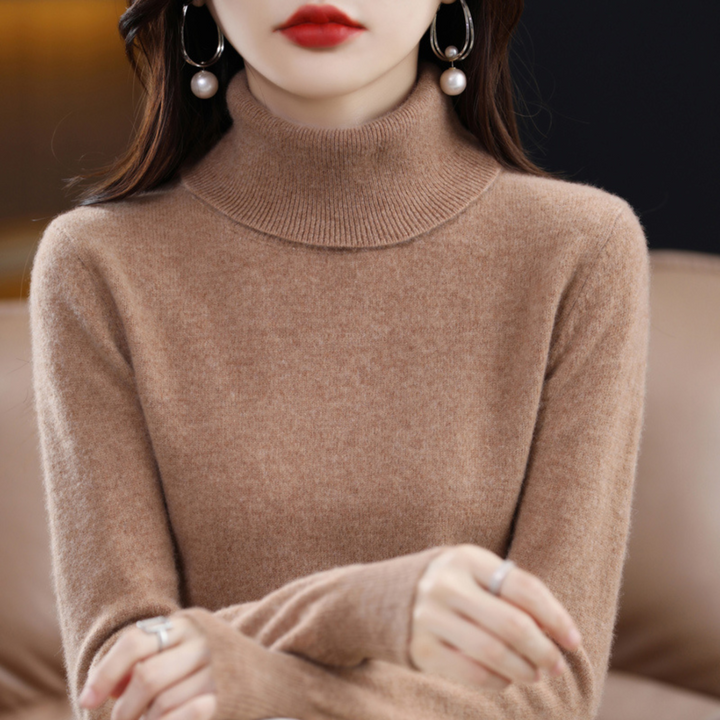 Model i karamelbrun rullekravesweater med ribstrikket krave og armene krydset foran kroppen. 14