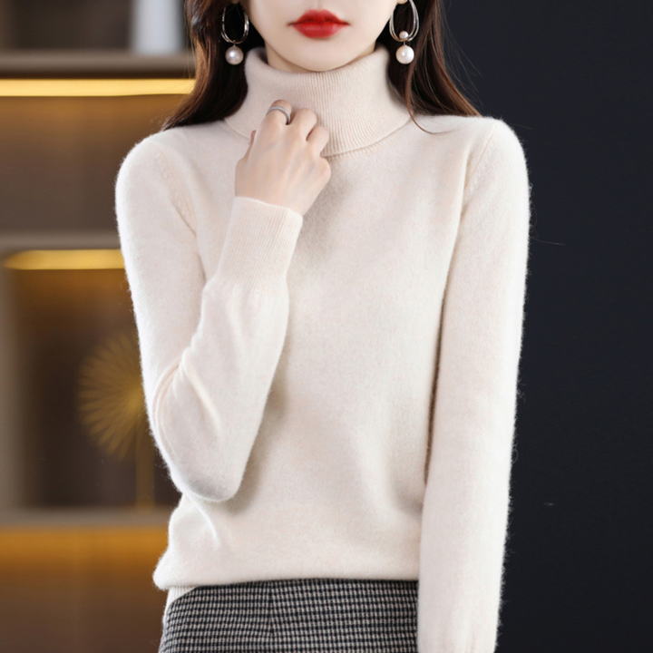 Model i cremehvid rullekravesweater med hånden op mod kraven, kombineret med ternet nederdel. 15